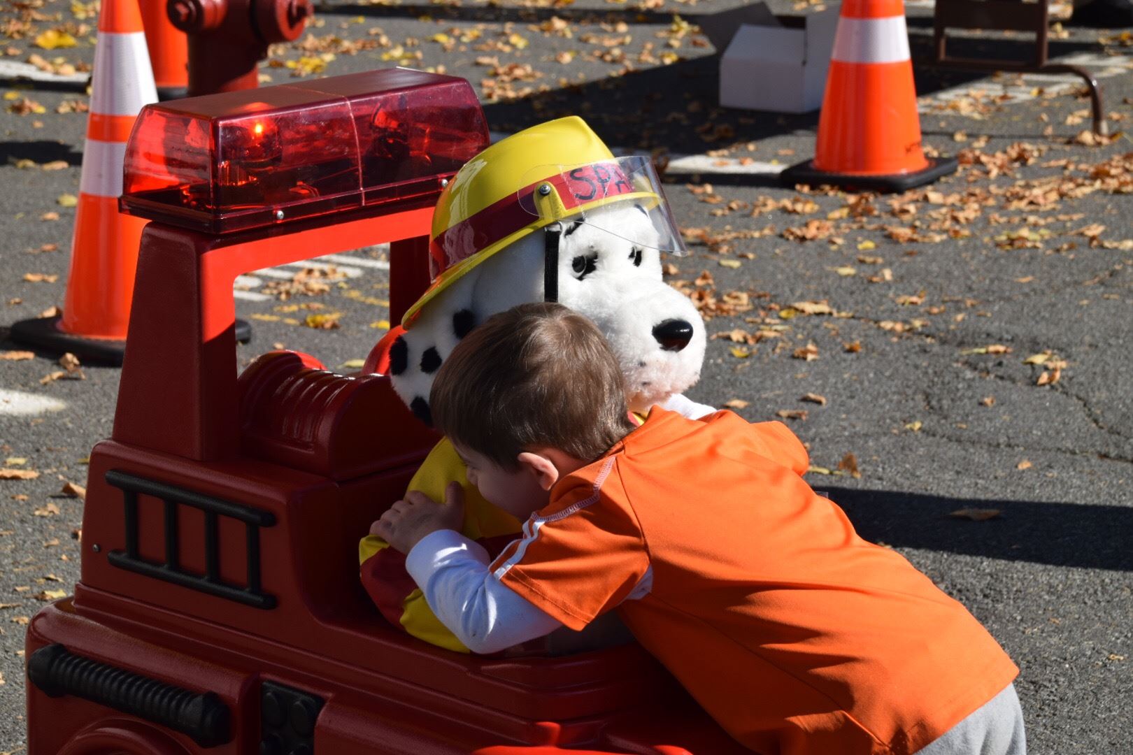Child hugging Sparky the Fire Dog