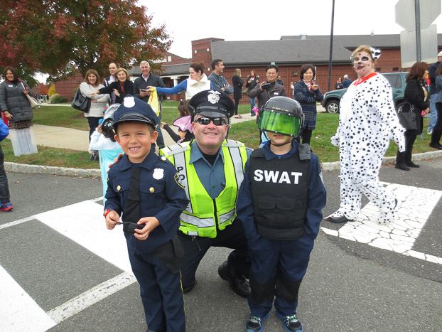 Officer smiling with two children in police costumes