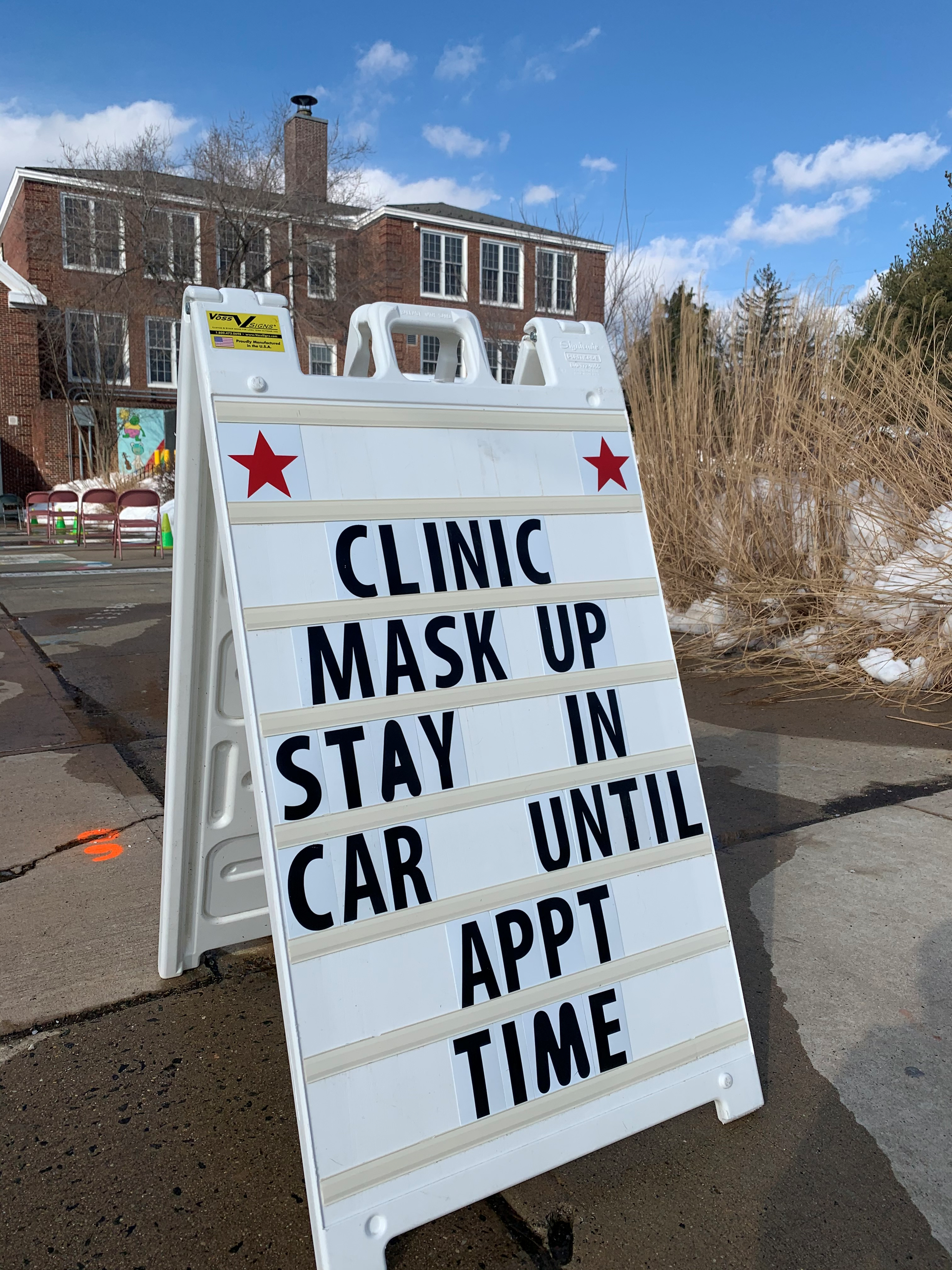 clinic sandwich sign saying mask up and wait in the car
