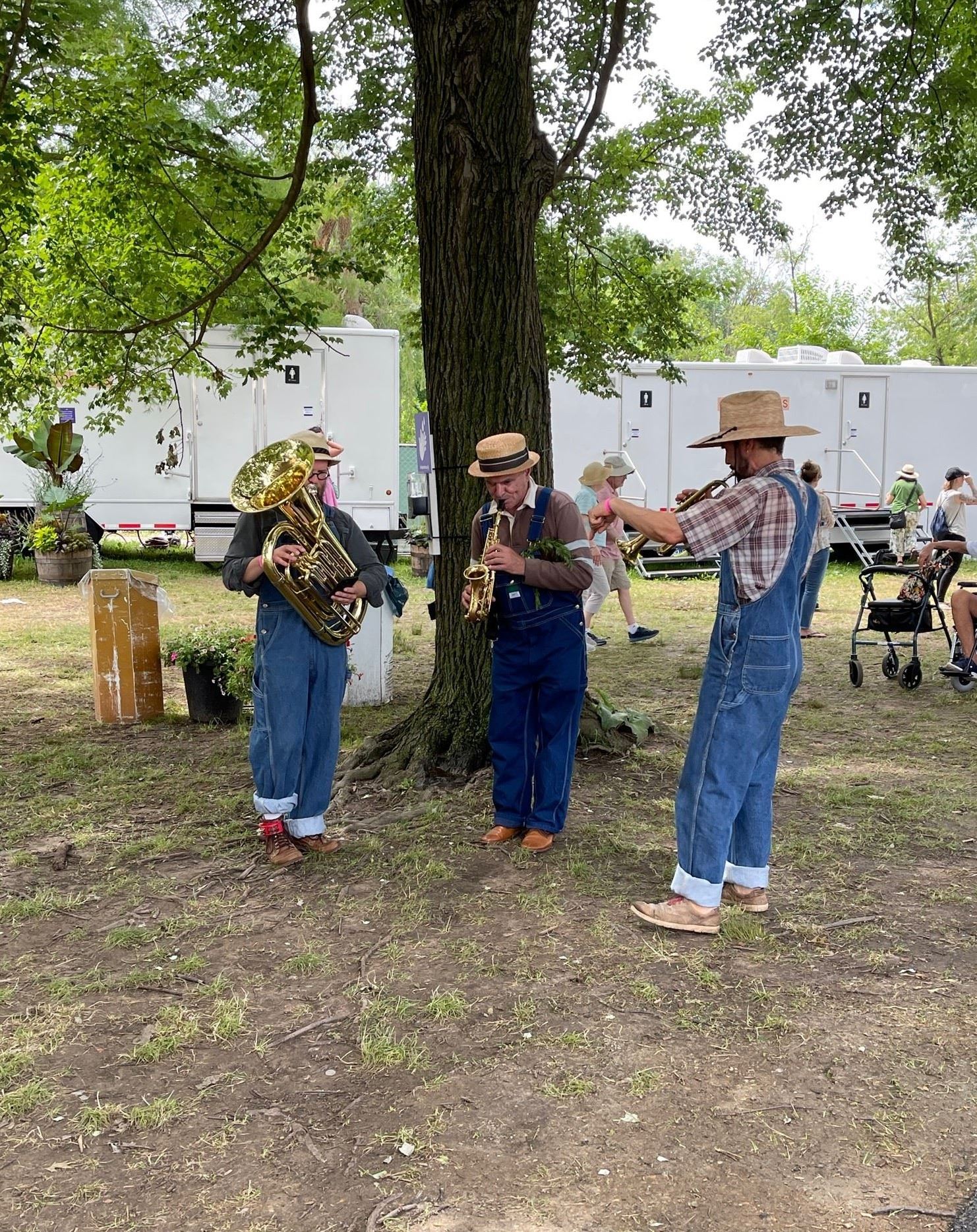3 brass musicians in overalls and straw hats