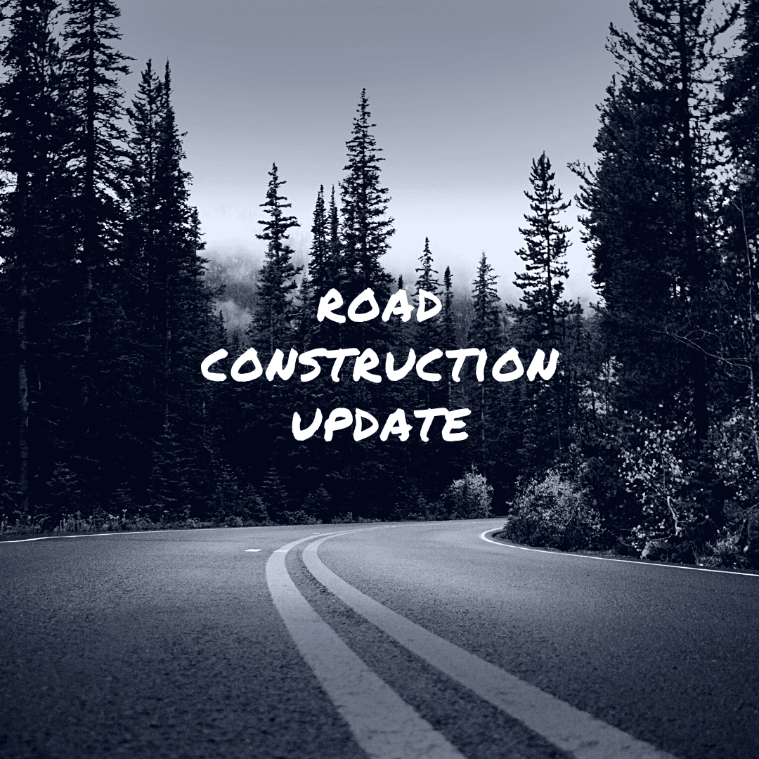 words of road construction update over a black and white image of a curving road and trees