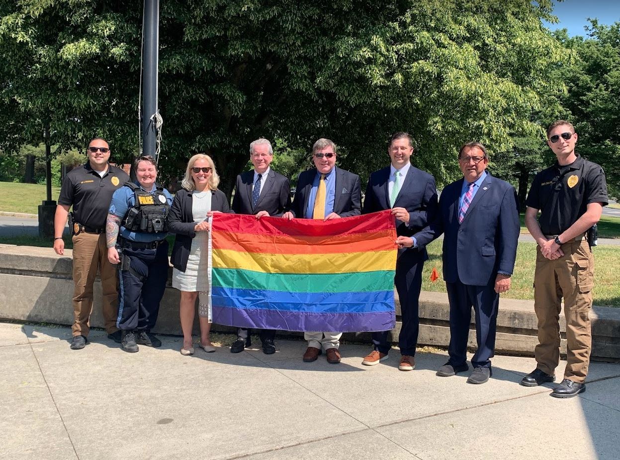 Elected officials and Police Department members holding the Pride flag 