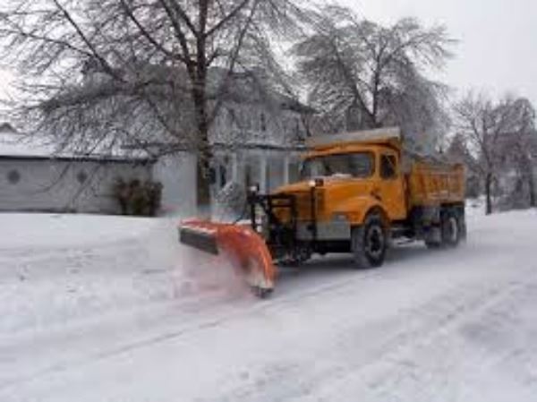 Large snow plow machine running through the streets clearing the snow after a storm