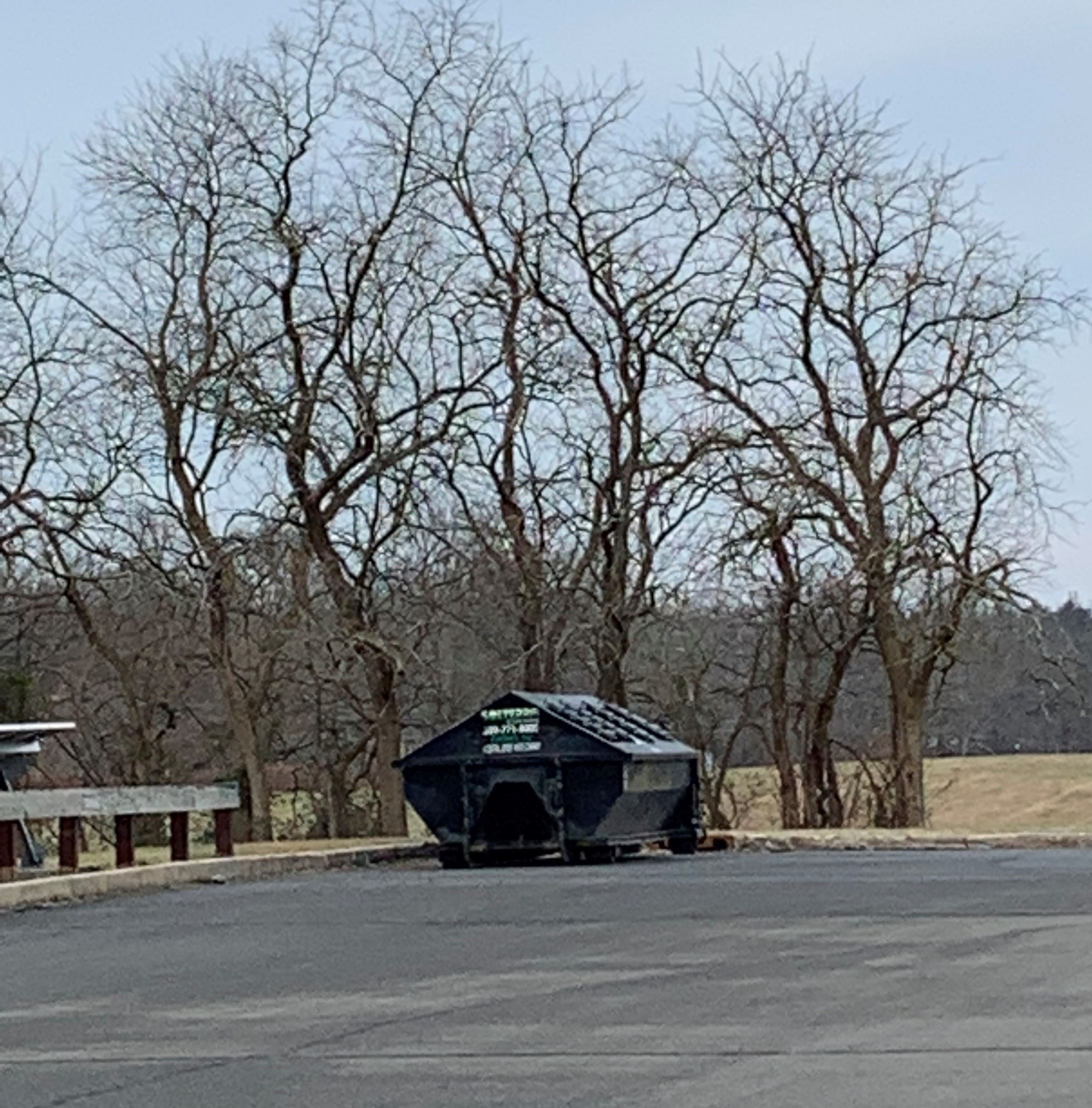 recycling bin in front of solar panels in parking lot