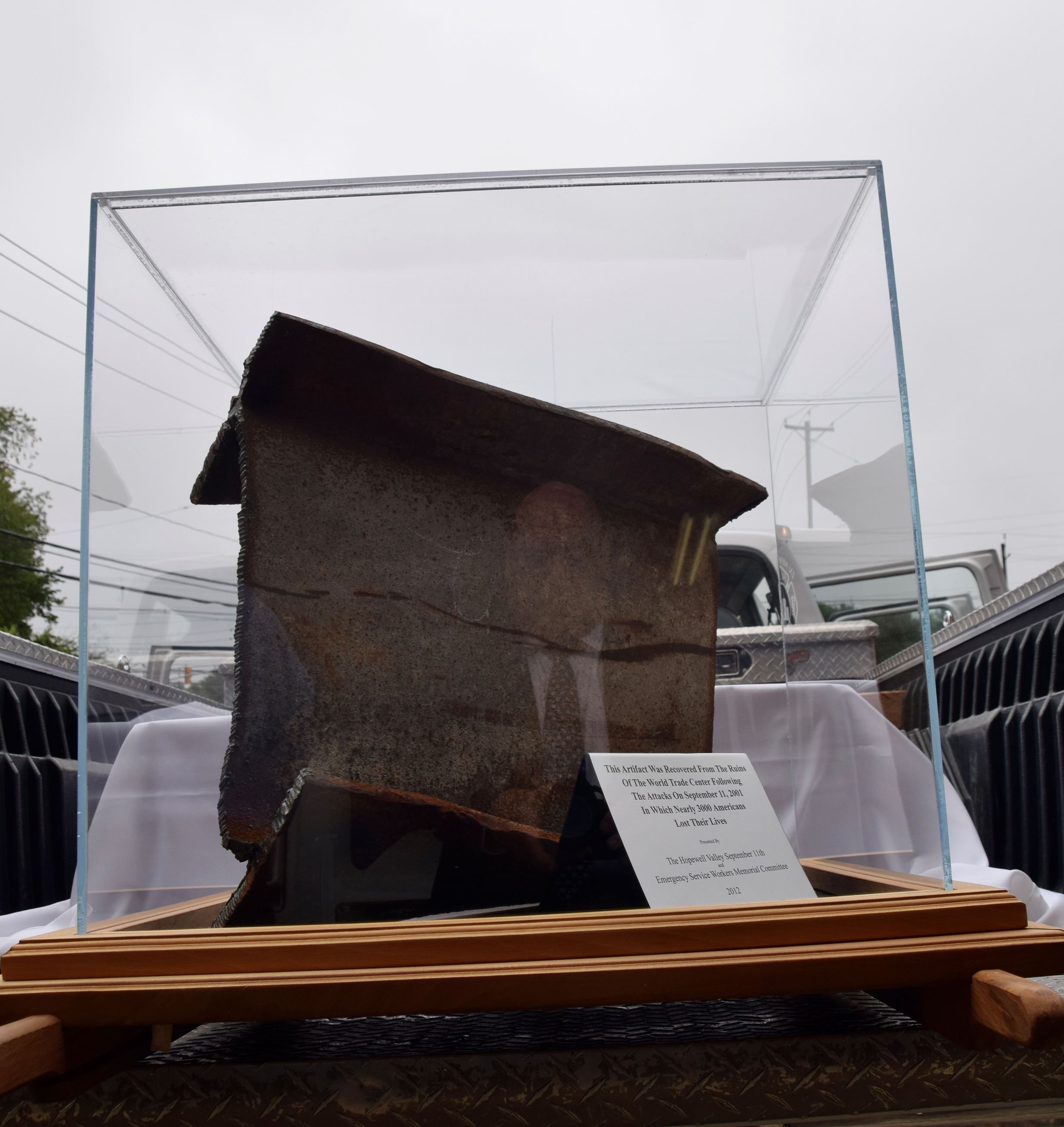 Photo of a piece of steel from the World Trade Center in a plexiglass box with a plaque description